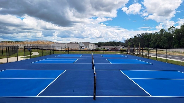 view of tennis court featuring fence and community basketball court