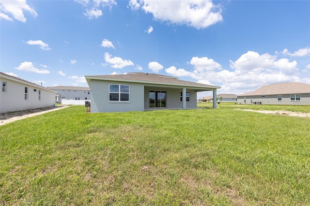 7536 SW 60th St, Ocala, FL 34476 - rear view of property with a yard and stucco siding
