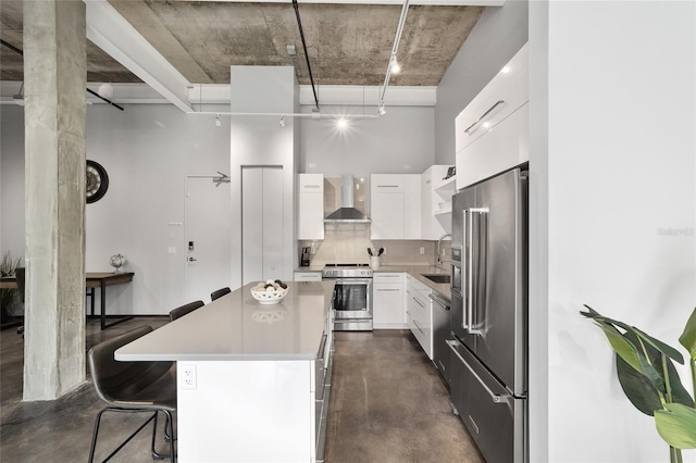 302 SE Broadway St Unit 240, Ocala, FL 34471 - kitchen featuring appliances with stainless steel finishes, wall chimney exhaust hood, finished concrete flooring, a center island, and a sink
