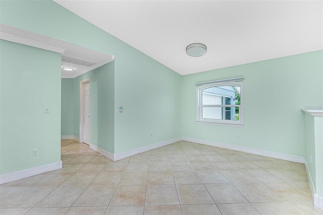 tiled spare room featuring baseboards
