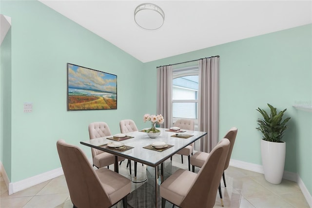 dining room featuring baseboards, light tile patterned floors, and lofted ceiling