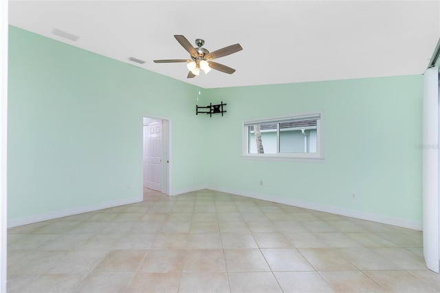 spare room featuring ceiling fan and baseboards