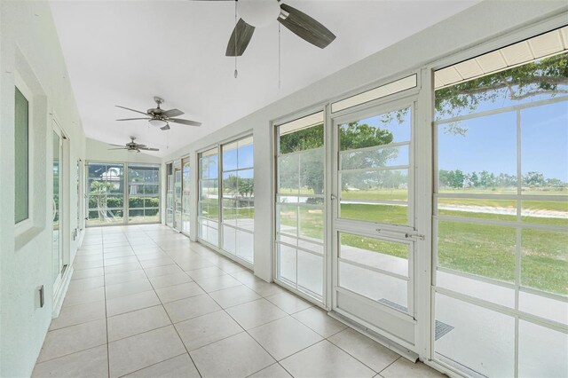 unfurnished sunroom featuring ceiling fan