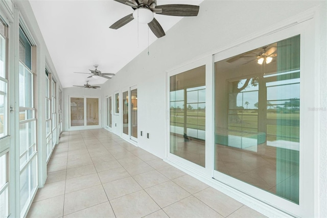 unfurnished sunroom featuring ceiling fan and vaulted ceiling