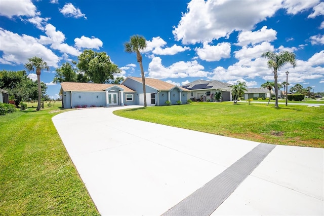 single story home featuring a front yard, concrete driveway, and a residential view