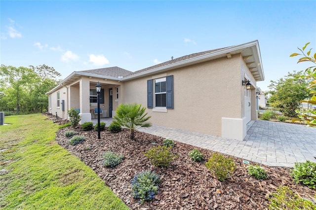 9309 SW 106th Ave, Ocala, FL 34481 - view of front of house with stucco siding, a front lawn, and cooling unit