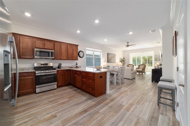 9309 SW 106th Ave, Ocala, FL 34481 - kitchen with stainless steel appliances, open floor plan, a peninsula, light wood-type flooring, and recessed lighting
