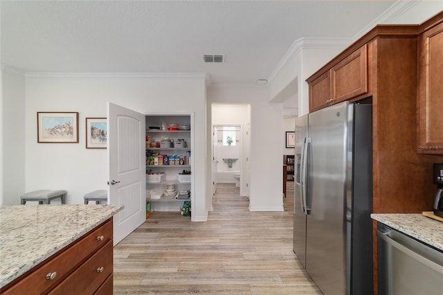 9309 SW 106th Ave, Ocala, FL 34481 - kitchen with appliances with stainless steel finishes, crown molding, light wood finished floors, light stone countertops, and brown cabinets