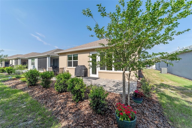 9309 SW 106th Ave, Ocala, FL 34481 - back of house with stucco siding, cooling unit, a patio area, and a lawn