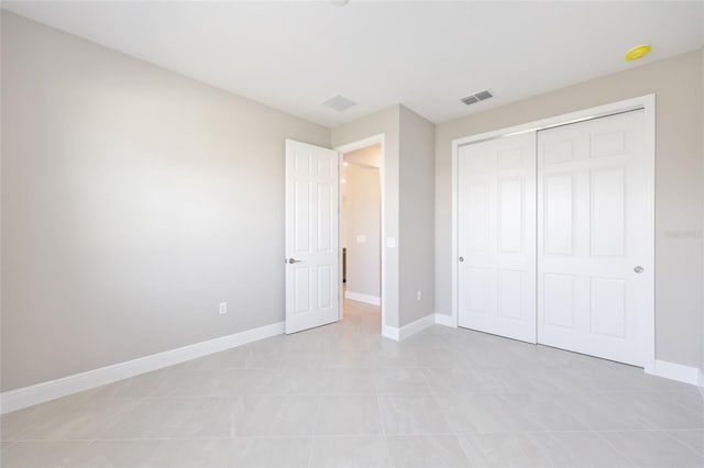 10569 SW 98th Pl, Ocala, FL 34481 - unfurnished bedroom with baseboards, a closet, and light tile patterned floors