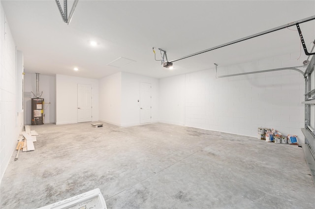 10569 SW 98th Pl, Ocala, FL 34481 - garage featuring water heater, a garage door opener, concrete block wall, and recessed lighting