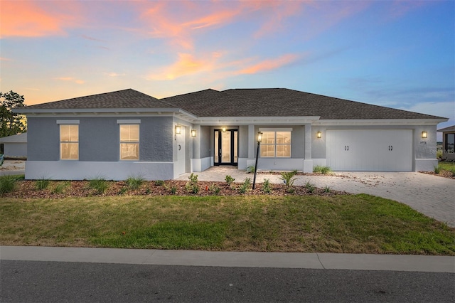 10976 SW 101st Loop, Ocala, FL 34481 - view of front of house with an attached garage, driveway, a front lawn, and stucco siding