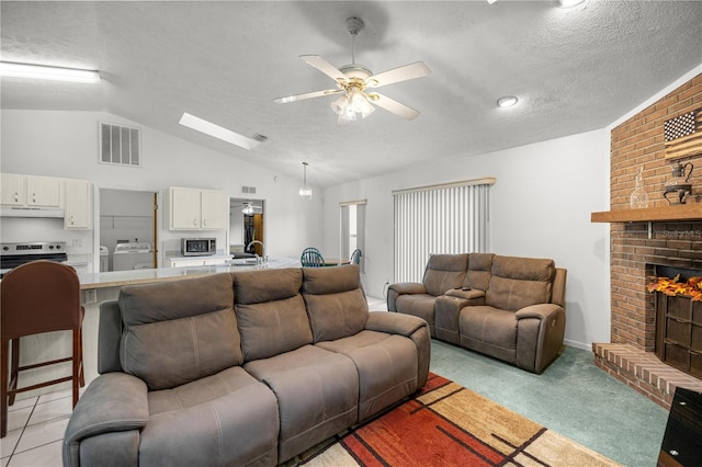 2521 NW 45th Pl, Ocala, FL 34475 - living room featuring vaulted ceiling, a textured ceiling, a ceiling fan, a brick fireplace, and light carpet