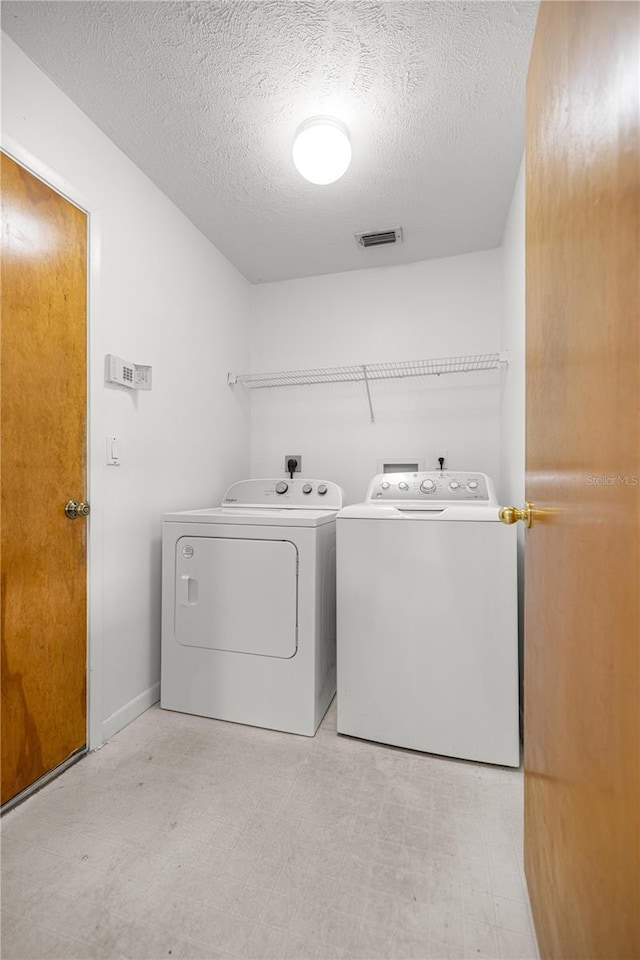 2521 NW 45th Pl, Ocala, FL 34475 - washroom featuring washer and clothes dryer, a textured ceiling, and light flooring
