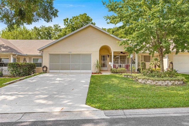 8710 SW 91st St Unit E, Ocala, FL 34481 - view of front of home with a front yard, brick siding, concrete driveway, a garage, and a ceiling fan