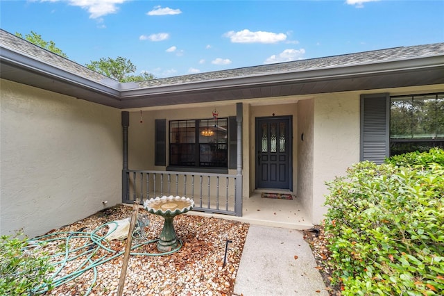 property entrance with stucco siding and a porch