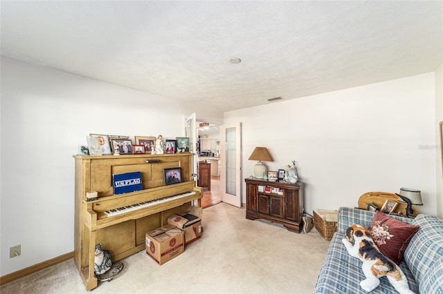 living area with light carpet and baseboards