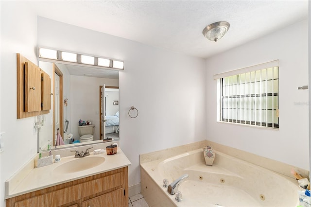 full bathroom featuring toilet, ensuite bathroom, a tub with jets, vanity, and tile patterned flooring