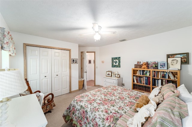 bedroom with light carpet, a closet, and a ceiling fan