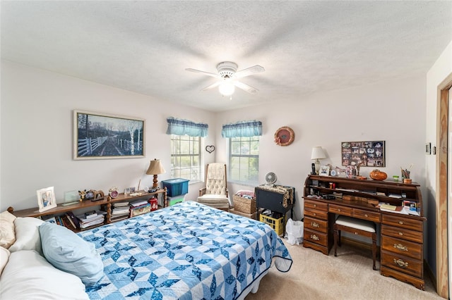 bedroom with light colored carpet, ceiling fan, and a textured ceiling