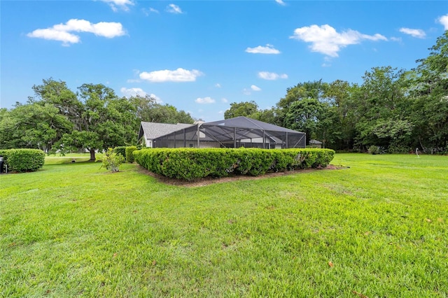 view of grassy yard featuring glass enclosure