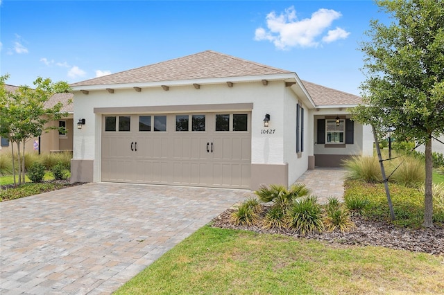 10427 SW 98th Place Rd, Ocala, FL 34481 - view of front facade with stucco siding, roof with shingles, decorative driveway, and a garage