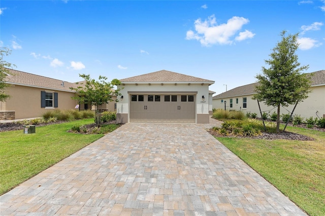 10427 SW 98th Place Rd, Ocala, FL 34481 - view of front of house with stucco siding, a front yard, decorative driveway, and a garage