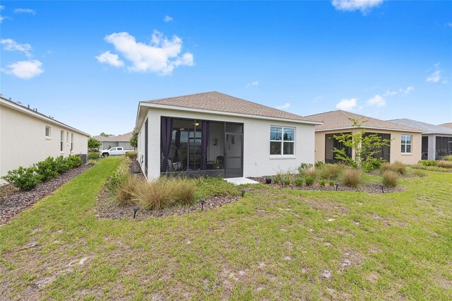10427 SW 98th Place Rd, Ocala, FL 34481 - rear view of house with a sunroom, a yard, and stucco siding