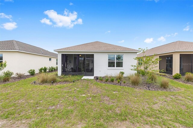 10427 SW 98th Place Rd, Ocala, FL 34481 - back of property featuring a sunroom, a lawn, and stucco siding