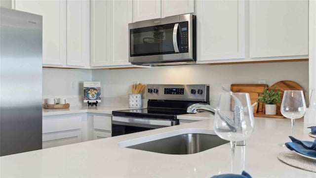 6569 SW 81st Loop, Ocala, FL 34476 - kitchen featuring stainless steel appliances, light countertops, and white cabinetry