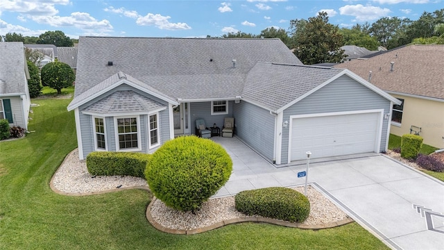 2608 Casso Ct, The Villages, FL 32162 - view of front of home with a garage, driveway, a front lawn, and a shingled roof
