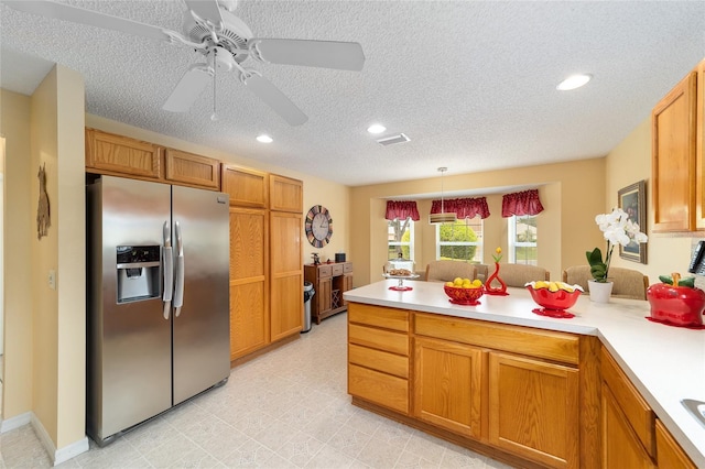 2608 Casso Ct, The Villages, FL 32162 - kitchen with stainless steel refrigerator with ice dispenser, a peninsula, light countertops, recessed lighting, and brown cabinets