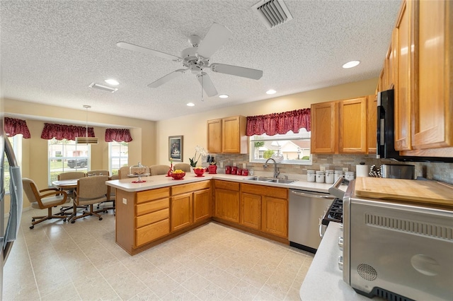 2608 Casso Ct, The Villages, FL 32162 - kitchen with a sink, dishwasher, healthy amount of natural light, a peninsula, and a textured ceiling