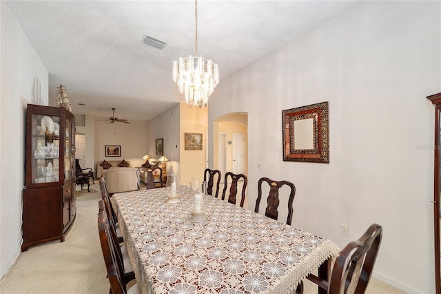 2608 Casso Ct, The Villages, FL 32162 - dining area featuring arched walkways, light colored carpet, a ceiling fan, and a chandelier