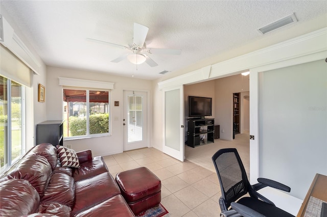 2608 Casso Ct, The Villages, FL 32162 - living room featuring light tile patterned floors, a ceiling fan, and a textured ceiling