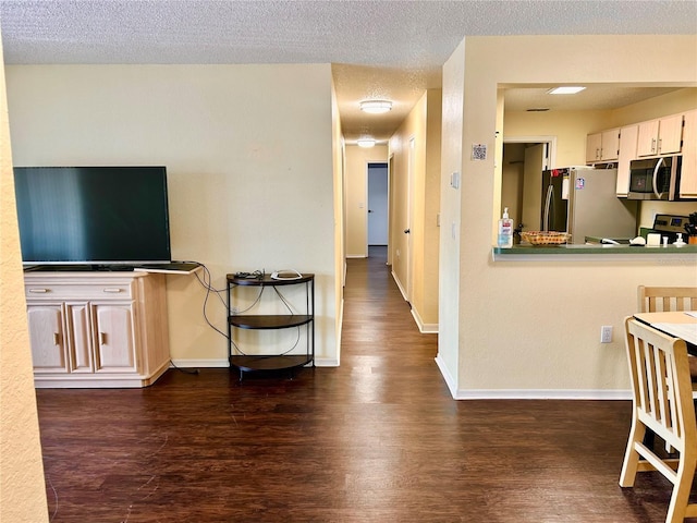 3705 SW 27th St Unit 621, Gainesville, FL 32608 - kitchen featuring stainless steel appliances, dark wood-type flooring, baseboards, and a textured ceiling