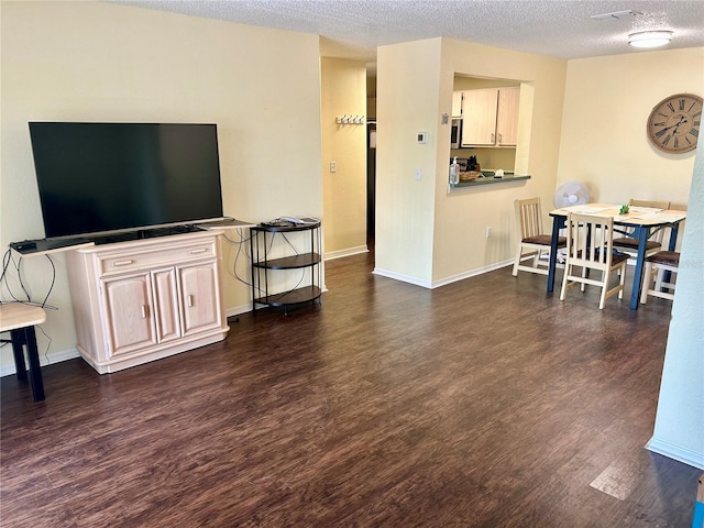 3705 SW 27th St Unit 621, Gainesville, FL 32608 - living room with dark wood finished floors, a textured ceiling, and baseboards