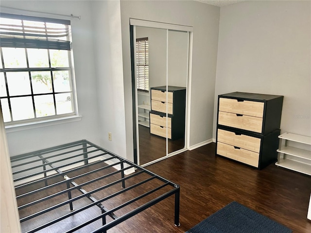 3705 SW 27th St Unit 621, Gainesville, FL 32608 - unfurnished bedroom featuring a closet, wood finished floors, and baseboards