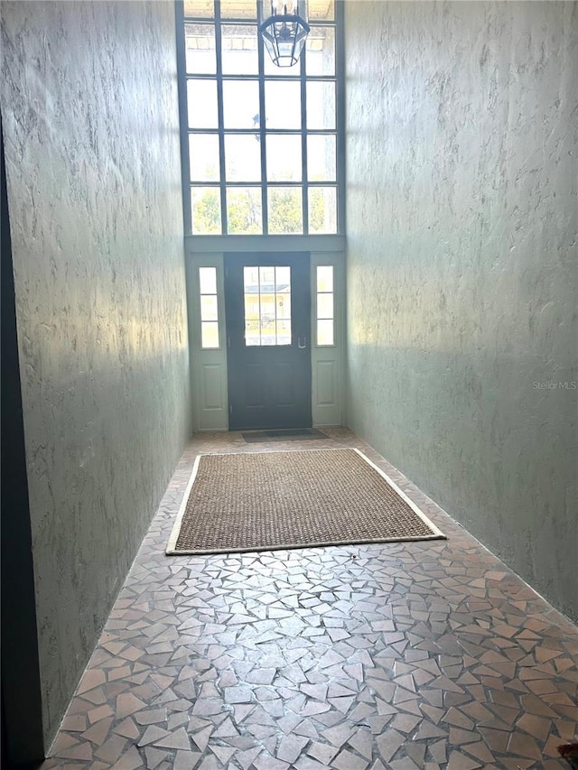 2715 NW 104th Ct Unit 1, Gainesville, FL 32606 - entryway featuring a towering ceiling, stone finish flooring, and a chandelier