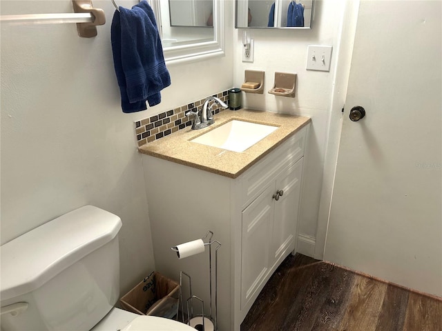 2715 NW 104th Ct Unit 1, Gainesville, FL 32606 - half bath with wood finished floors, toilet, vanity, and decorative backsplash
