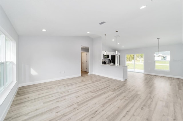 unfurnished living room with light wood-type flooring, a chandelier, baseboards, recessed lighting, and lofted ceiling