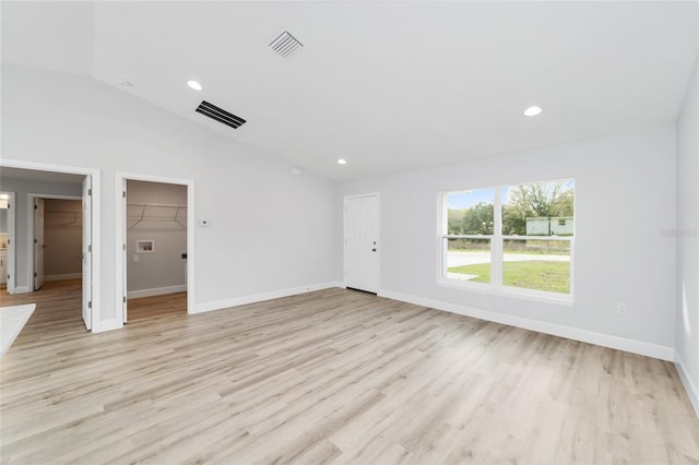 unfurnished living room featuring light wood-style flooring, vaulted ceiling, baseboards, and recessed lighting