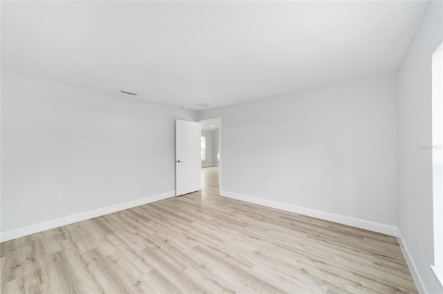 spare room with light wood finished floors and baseboards