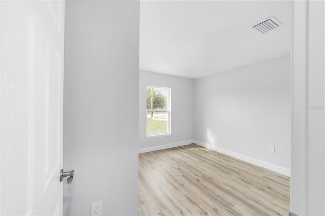 spare room with wood finished floors and baseboards