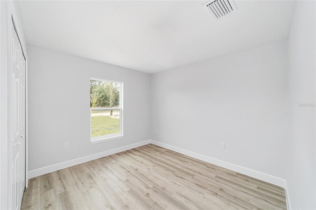 unfurnished bedroom with light wood-style flooring, baseboards, and a closet