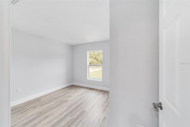 spare room with light wood-style flooring and baseboards