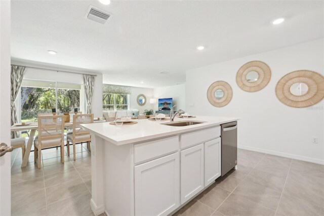 kitchen featuring a sink, dishwasher, light tile patterned floors, white cabinetry, and recessed lighting