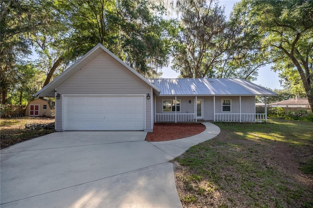 9 Juniper Pass Trl, Ocala, FL 34480 - ranch-style house featuring covered porch, concrete driveway, an attached garage, and metal roof