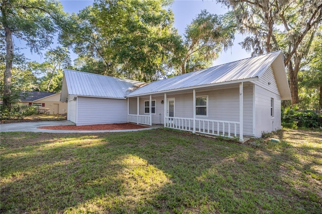 9 Juniper Pass Trl, Ocala, FL 34480 - ranch-style home featuring covered porch, a front yard, metal roof, and concrete driveway