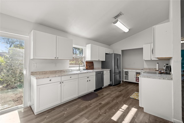 9 Juniper Pass Trl, Ocala, FL 34480 - kitchen featuring appliances with stainless steel finishes, a sink, vaulted ceiling, white cabinetry, and light countertops